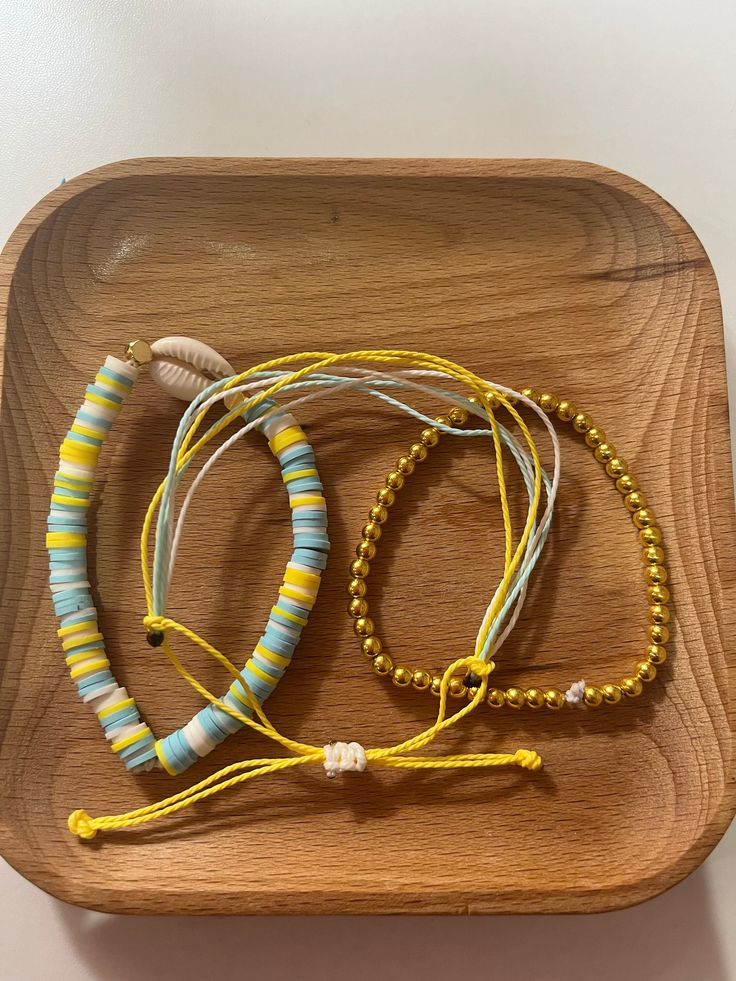 Cute two bracelets that contain gold, blue, yellow, and white. Puka shell on one of them. String bracelet as the other. Both very comfy and stretchy. Starfish Anklets, Peace Bracelet, Summer Anklets, Yellow Bracelet, Gold Bracelet Set, Puka Shell, Shell Bracelet, Personalized Wall, String Bracelet