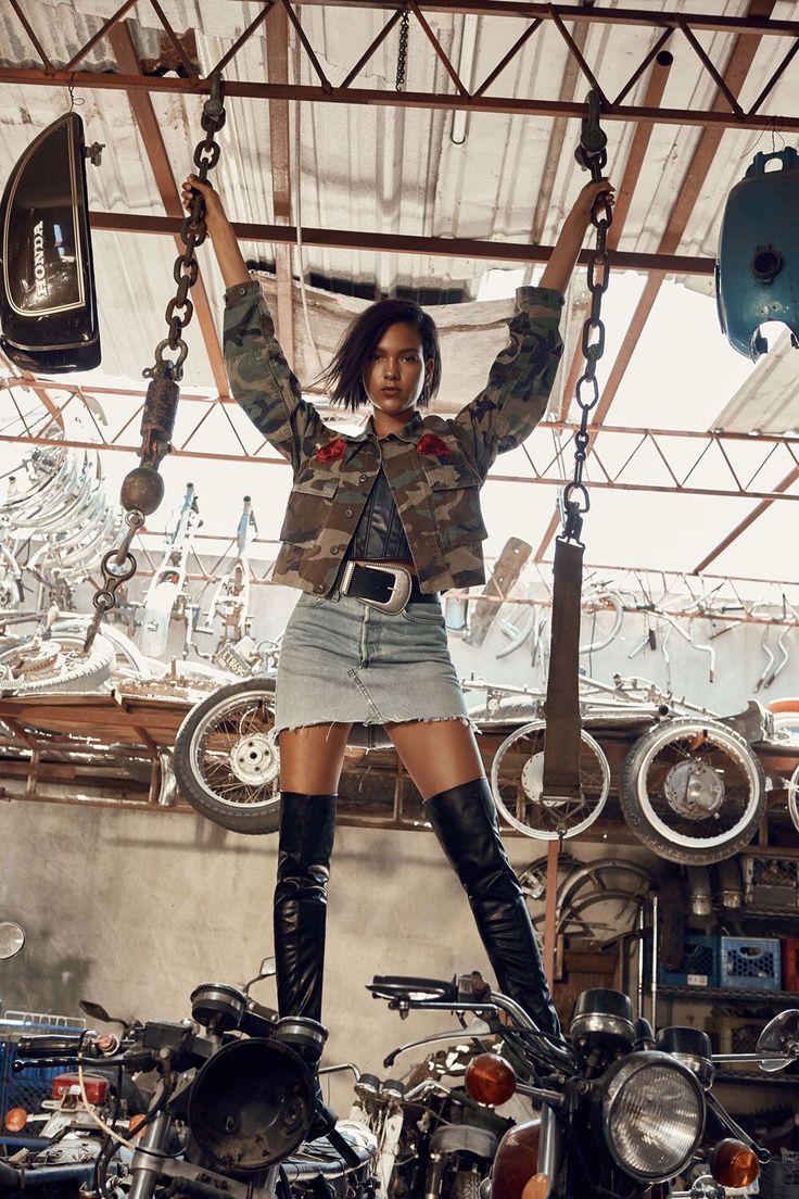 a woman standing on top of a motorcycle with chains attached to the back of it