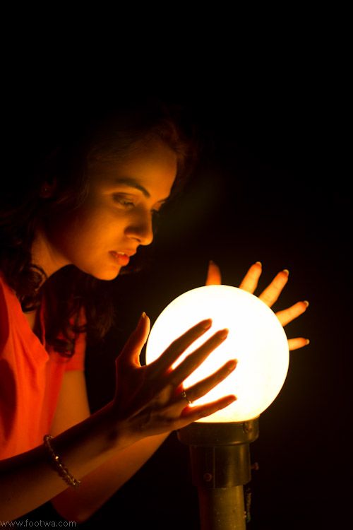 a woman holding a glowing ball in her hands