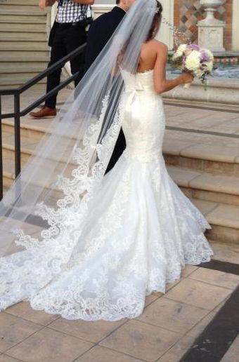 the bride is walking down the stairs in her wedding dress