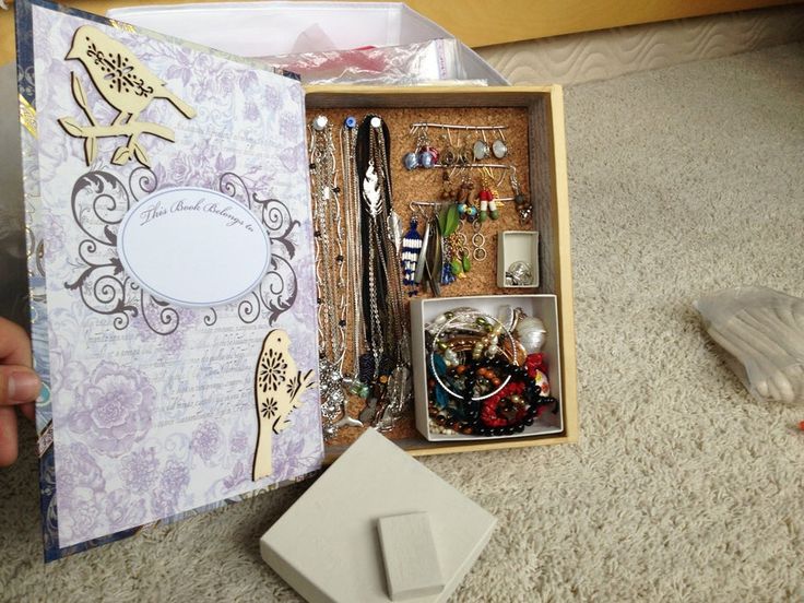 an open box with jewelry inside sitting on the floor next to a mouse and other items