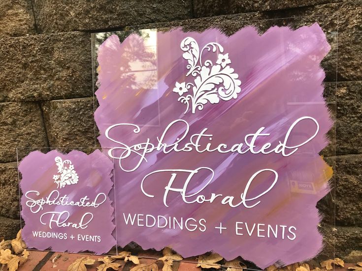 the sign for sophisticated floral wedding and events in front of a stone wall with leaves on it