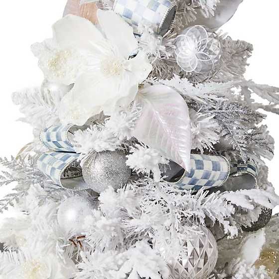 a white christmas tree with silver ornaments and flowers