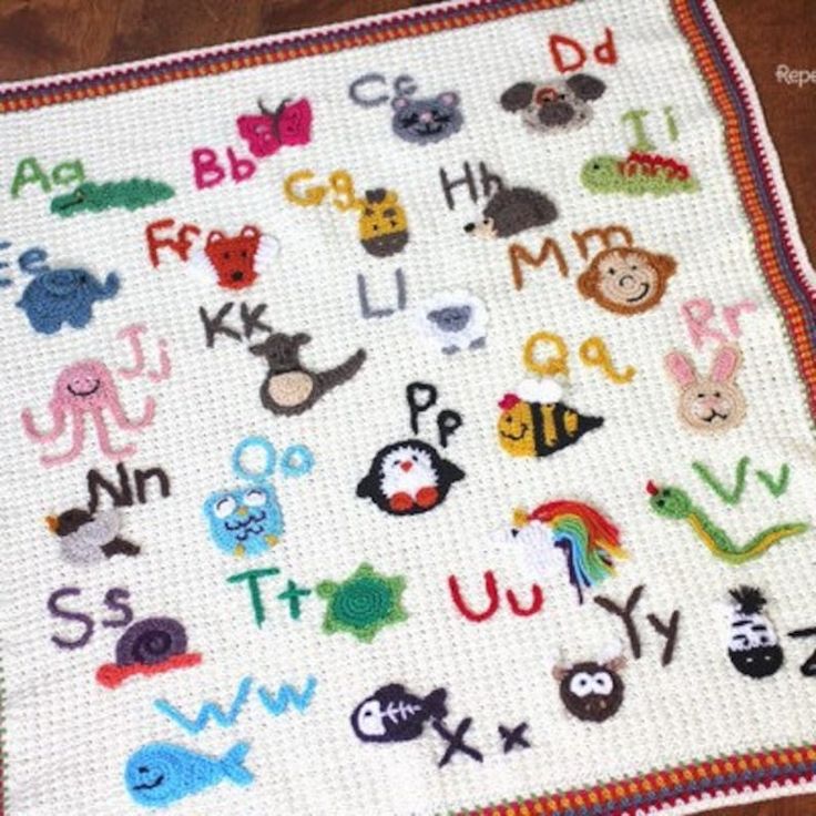 a crocheted blanket with letters and animals on it