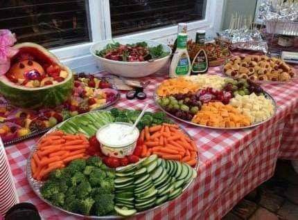 an assortment of fruits and vegetables are on a table in front of a store window