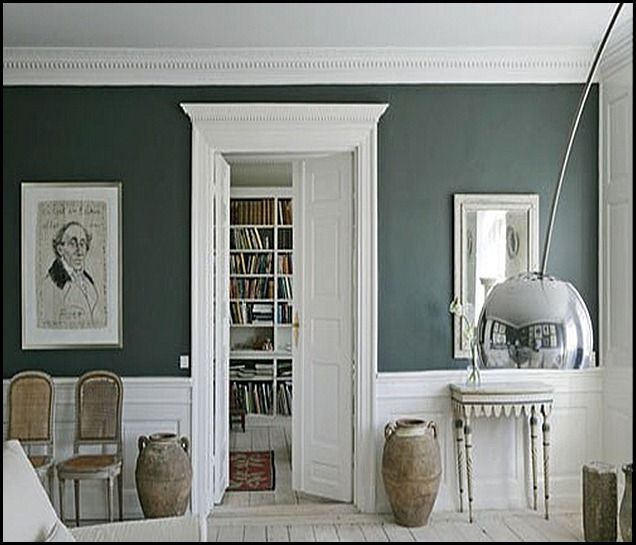 a living room filled with furniture and bookshelves next to a doorway that leads into a library