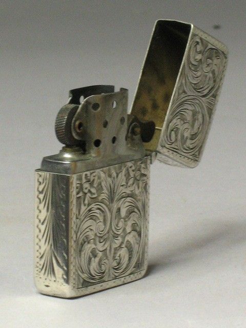 an old silver flask style lighter on a white background