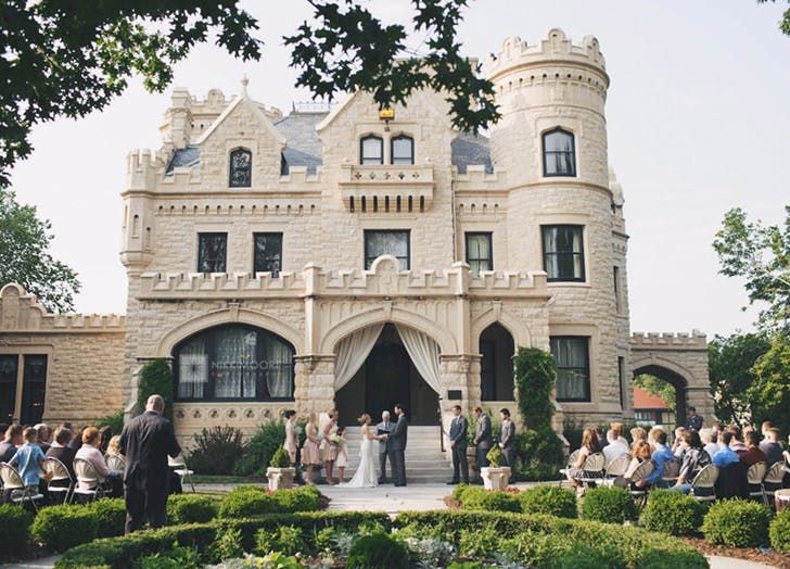 a wedding ceremony in front of a castle like building