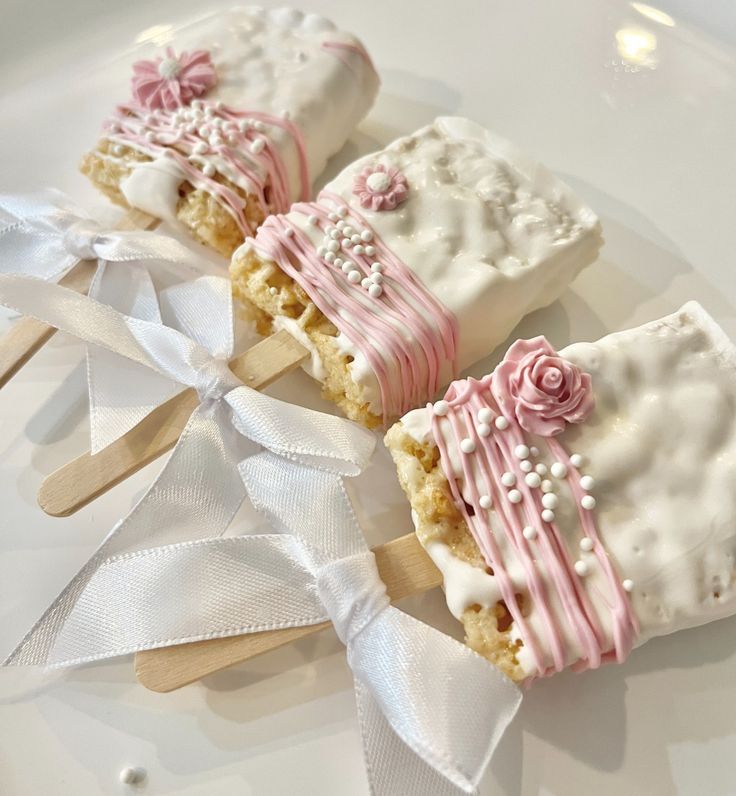 some kind of dessert on a plate with white ribbon around it and pink flowers in the middle