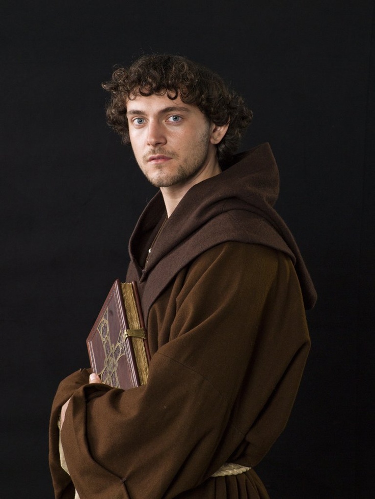 a man dressed in medieval clothing holding a book