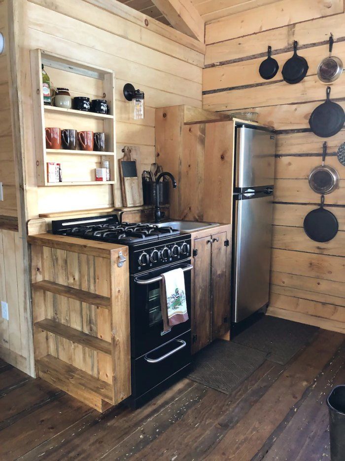 a stove top oven sitting inside of a kitchen next to a wooden counter and wall