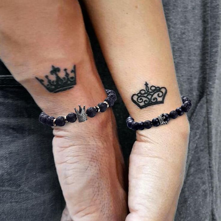 two people with matching tattoos on their arms, both wearing bracelets and crown tattoo designs