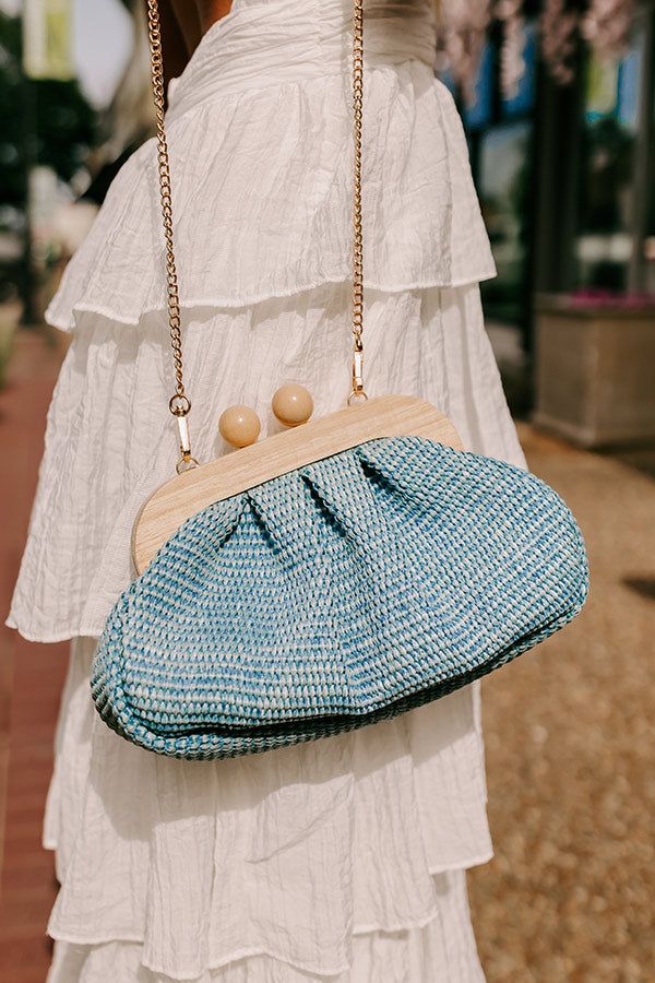 - Pull your look together with this sweet purse! Its woven design and wooden clasp make it the perfect for summer style. It easily elevates your OOTD giving it a laid-back yet chic vibe. - A fully lined pouch - Woven raffia material - Gold colored metal hardware - A magnetic wooden ball clasp closure - A removable chain strap - A zippered interior pocket Blue Woven Straw Bag For Spring, Blue Woven Bags For Spring, Spring Woven Clutch For Everyday Use, Chic Woven Clutch For Spring, Chic Clutch For Summer Day Out, Chic Clutch For A Summer Day Out, Chic Summer Clutch For A Day Out, Chic Blue Woven Straw Bag, Blue Rectangular Clutch For Spring