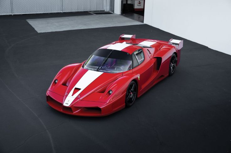 a red and white sports car parked in a garage