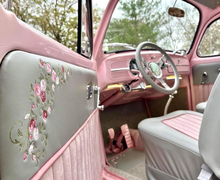 the interior of an old pink car with flowers painted on it's side door