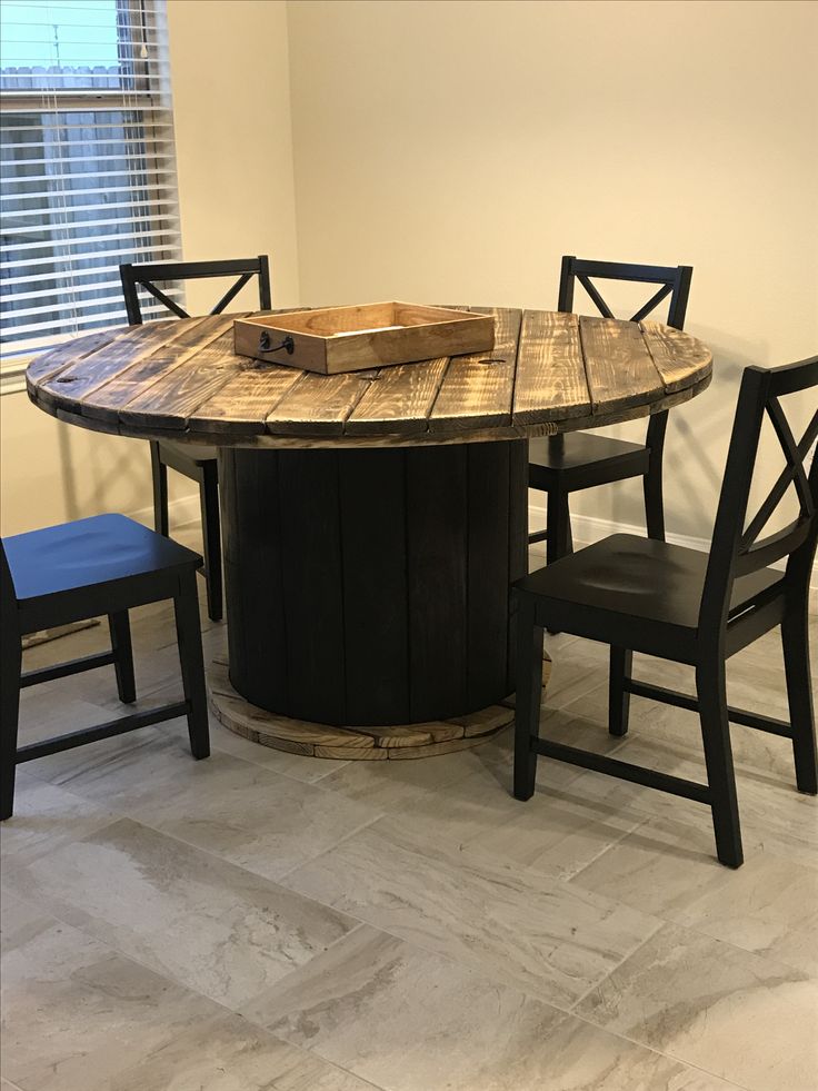 a kitchen table with chairs around it and a wooden box sitting on top of the table