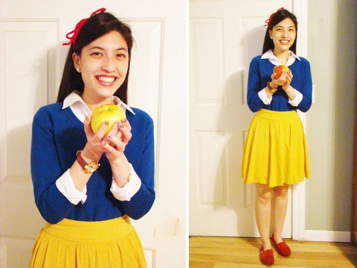 a woman in a blue shirt and yellow skirt holding an apple while standing next to a door