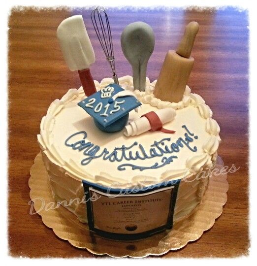 a cake decorated with utensils and the words congratulations on it is sitting on a table