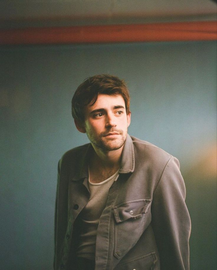 a man standing in front of a green wall