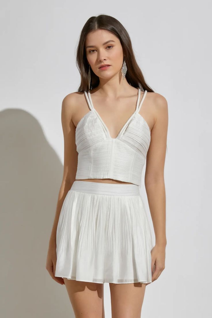 The Meant To Be Cami Top is just what you need for fun days in the sun! Pleated woven fabric shapes this flirty top that has a deep V-neckline, sleeveless bodice, and bustier-style seaming that is supported by wide, rope straps that crisscross at the back. The fitted waist ends at a cropped hem and smocked back. Complete the set look with the Meant To Be White Pleated Shorts. Cami Top Color: White Fit: True to size Deep V-neckline Bustier-style seaming Wide rope shoulder straps Crisscross back H White Cami Top, White Cami Tops, Flirty Tops, White Cami, Pleated Shorts, Line Store, Sleeveless Crop Top, Cami Top, Cami Tops