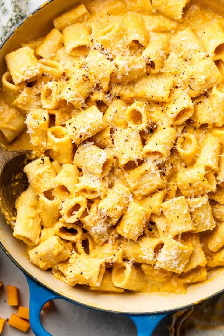 a pan filled with pasta and cheese on top of a table next to other ingredients