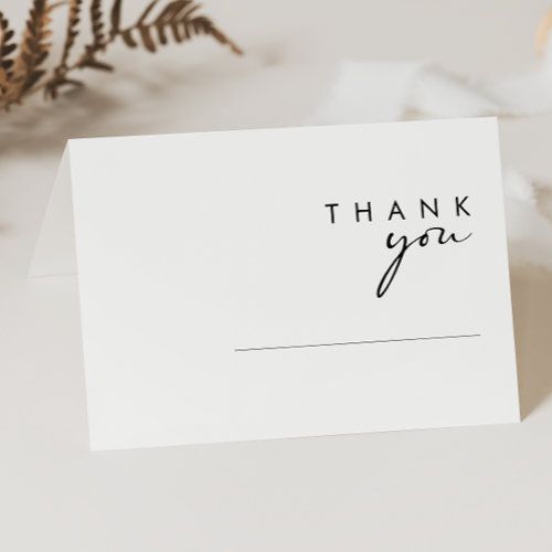 a thank you card sitting on top of a table next to some flowers and leaves