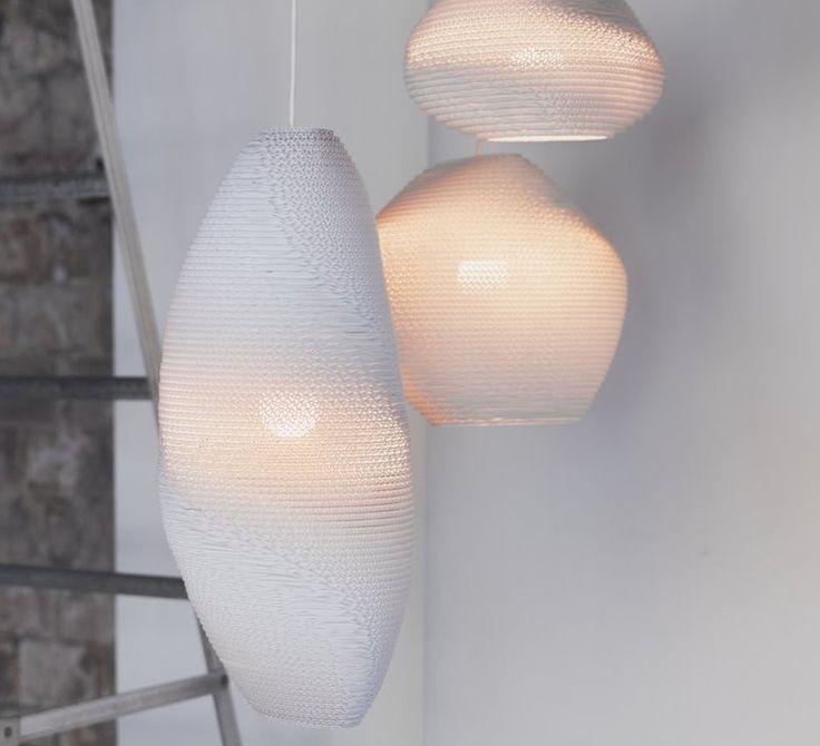 three white lamps hanging from the ceiling in a room