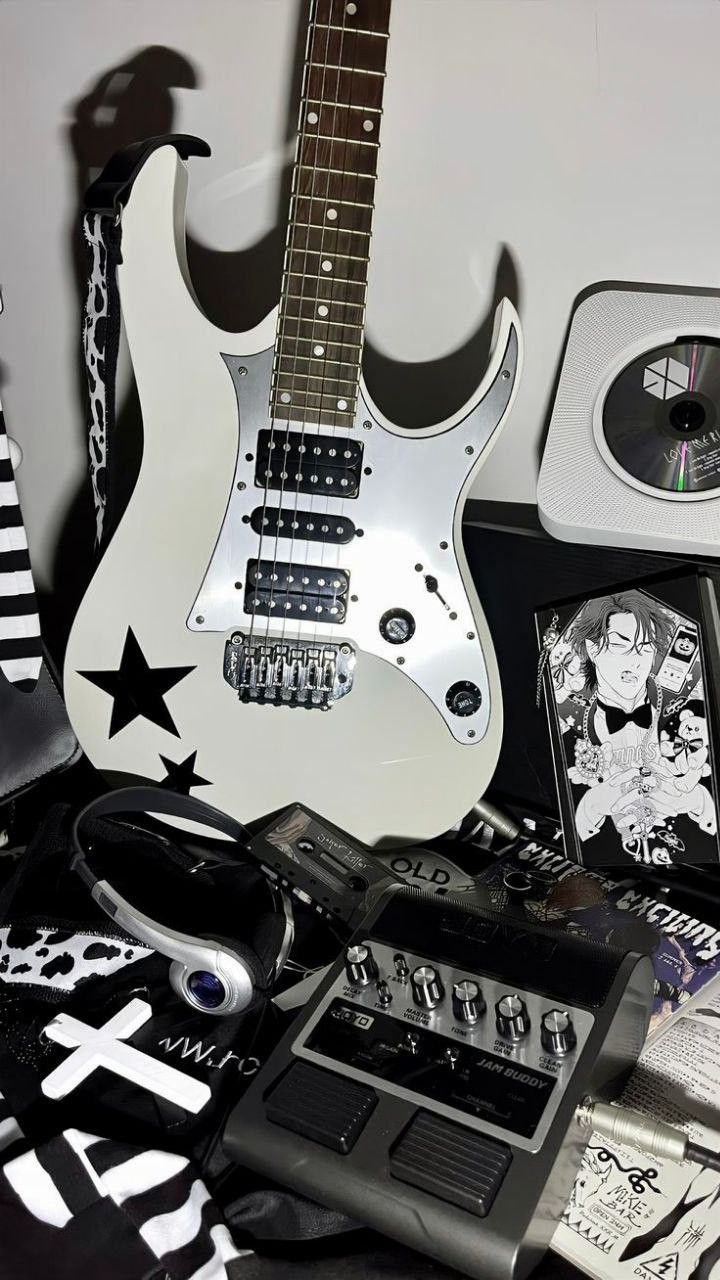 black and white photograph of guitar, cd's, and other items