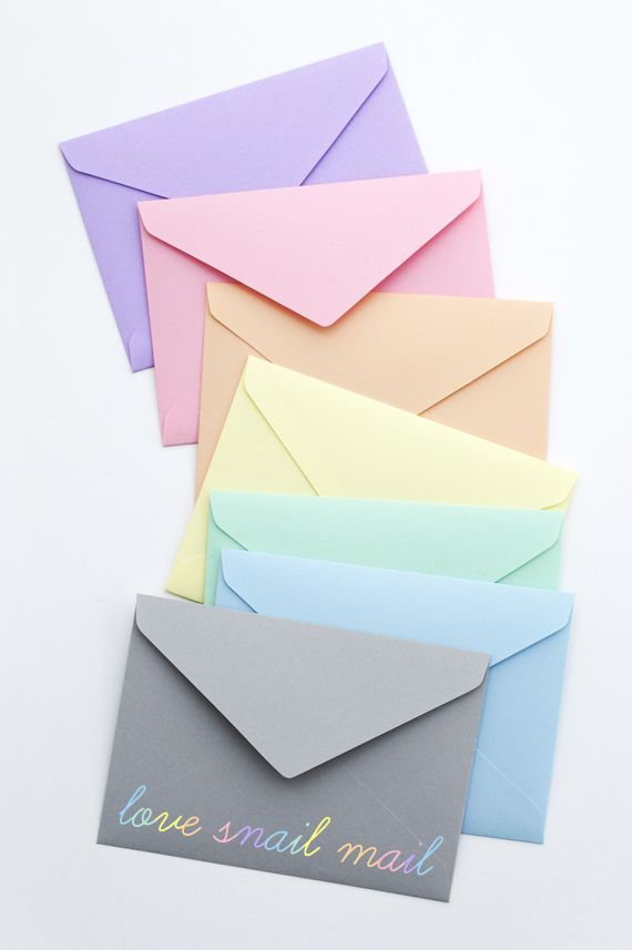 several different colored envelopes with the word love small mail written on them, all stacked together