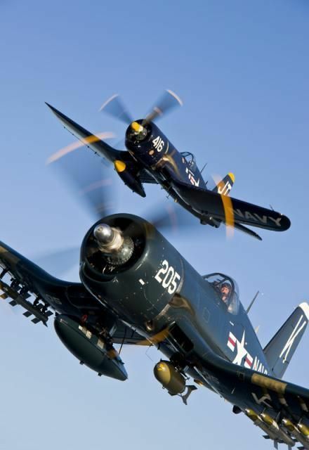 two airplanes flying in the sky with propellers