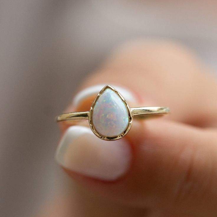 Also known for giving peace of mind and encouraging creativity, 14K Gold White Opal Ring is also the birthstone of October. The ring is made of 14k solid gold. Please note that it is not gold plated or gold filled. This beautiful ring is ideal for those with sensitive skin as it is hypoallergenic. You can choose from white gold, yellow gold, or rose gold. Additionally, if you prefer a natural opal instead of the synthetic opal in this design, we can make that change for you. Please note that a s Teardrop Opal Ring, 14k Gold Teardrop Ring, Teardrop Opal Promise Ring Fine Jewelry, Teardrop Opal Promise Ring In Fine Jewelry Style, Teardrop Opal Ring For Gift, White Teardrop Promise Jewelry, White Teardrop Jewelry For Promise, Spiritual Teardrop Gemstone Rings, Spiritual Teardrop Rings For Anniversary