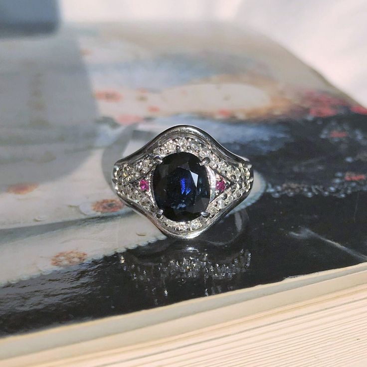 This 14k Gold ring features a 2.59ct dark blue sapphire with natural diamonds & rubies. The design is simple, and the ring will be the good & affordable gift for all occasion, whether it's for birthday, anniversary, for your wife or girlfriend💍 Available in multiple colors of 14k Gold: Yellow, White and Rose for an additional fee. Resizing is also available. - Details - Ring size: US 6 3/4 (11 3/4) Diamond weights: 34p, 0.42cts Center Stone: Dark Blue Sapphire Approx Weight: 2.59ct Approx Dimension: 7.4*9.15mm - Shop Policies - 180-days warranty with purchase. SHIPPING: All purchases are processed within 2-3 business days. Items that are made to order will be shipped within the projected date shared with you during the purchase. We will provide the delivery details for the orders for cust Multi-stone Round Cut Sapphire Ring, Multi-stone Sapphire Round Ring, Sapphire Diamond Ring With Accent Stones, Multi-stone Sapphire Ring For Promise, Multi-stone Sapphire Birthstone Ring, Sapphire Cluster Ring With Accent Stones, Lab-created Sapphire Ring With Accent Stones, White Gold Pink Sapphire Ring, Gold Sapphire Engagement Ring