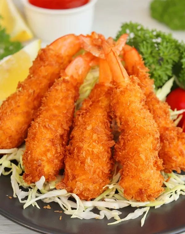 fried shrimp sticks on a black plate with parmesan cheese and lettuce