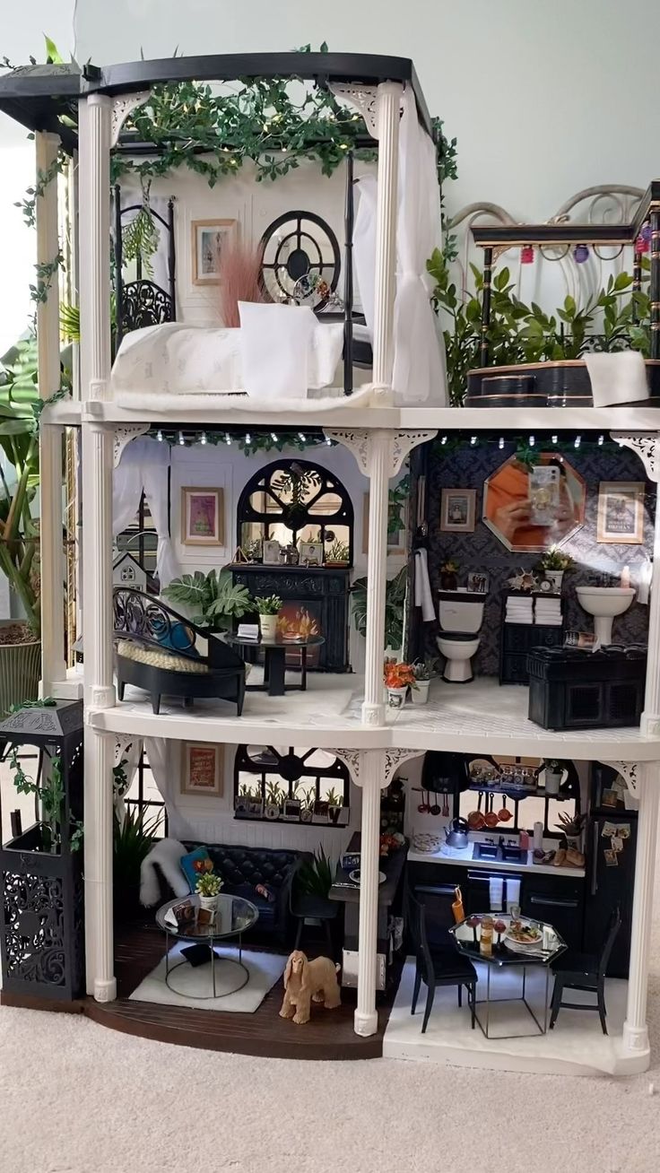 a doll house with lots of furniture and plants on the top floor in front of it