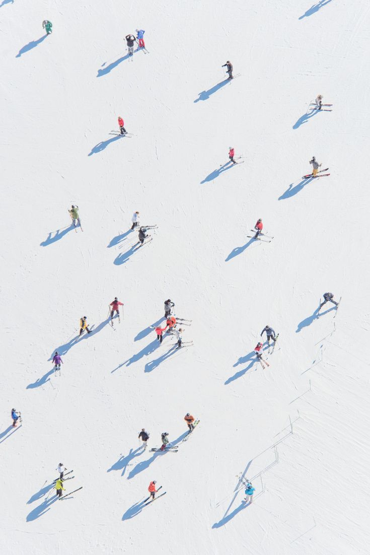 an aerial view of people skiing down a hill