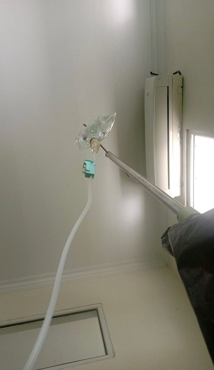 an electric toothbrush is hooked up to the wall in front of a window with light coming through it