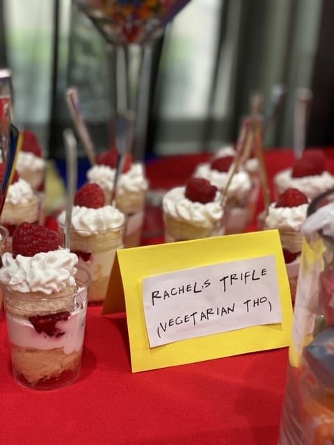 small desserts are arranged on a red tablecloth with a sign that says rachel's triple vegetarianin thi