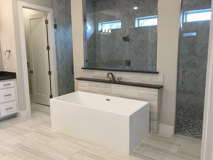 a large white bath tub sitting inside of a bathroom next to a walk in shower