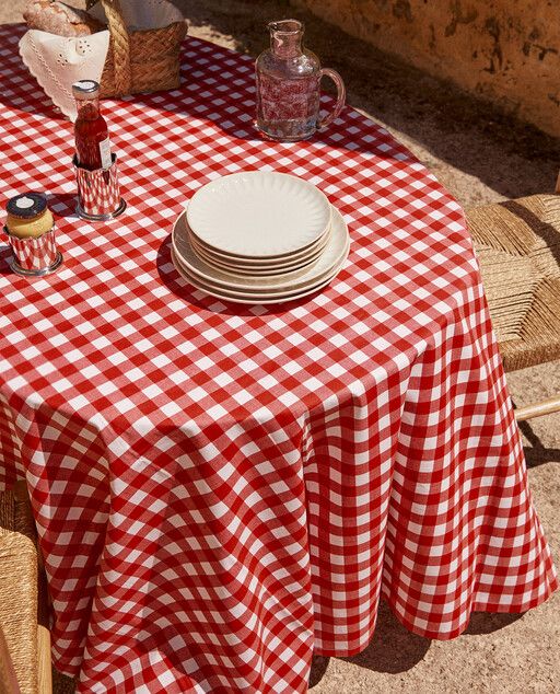 a red and white checkered table cloth with plates on it