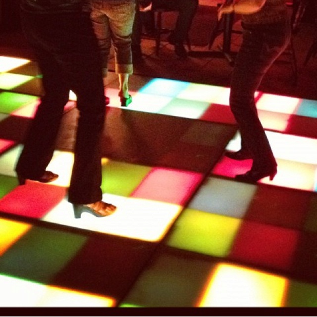 two people are dancing on a colorful floor