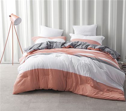 an orange and white bed is in front of a wall with vertical striped curtains on it