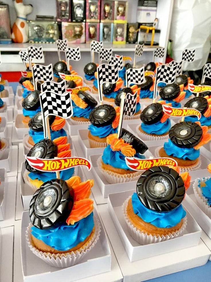 cupcakes with cars and flags are on display at a race car themed birthday party