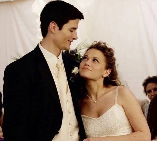 a bride and groom standing next to each other in front of a group of people