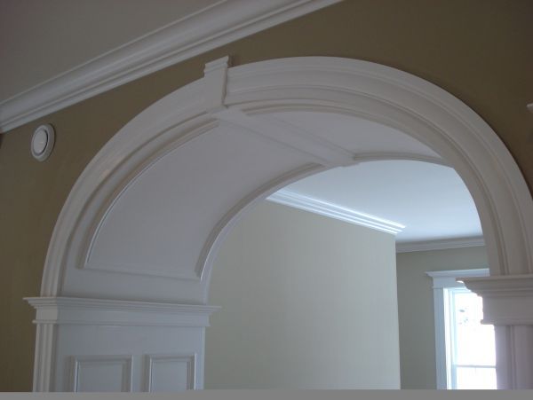 an arch in the middle of a room with white walls and trimmings on it