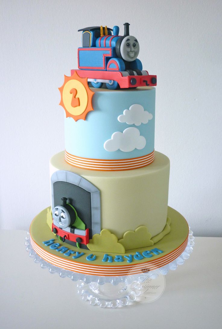 a thomas the train birthday cake with fondant decorations on it's top tier