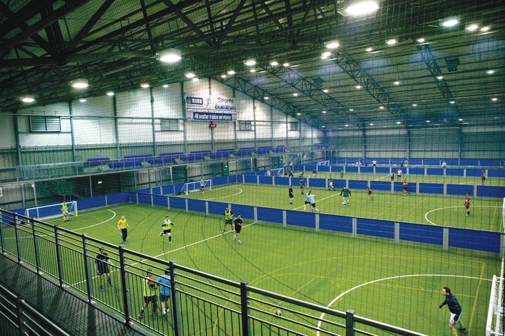 an indoor soccer field with several players on the field and in the middle of it