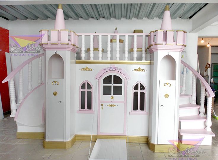 a pink and white doll house with stairs