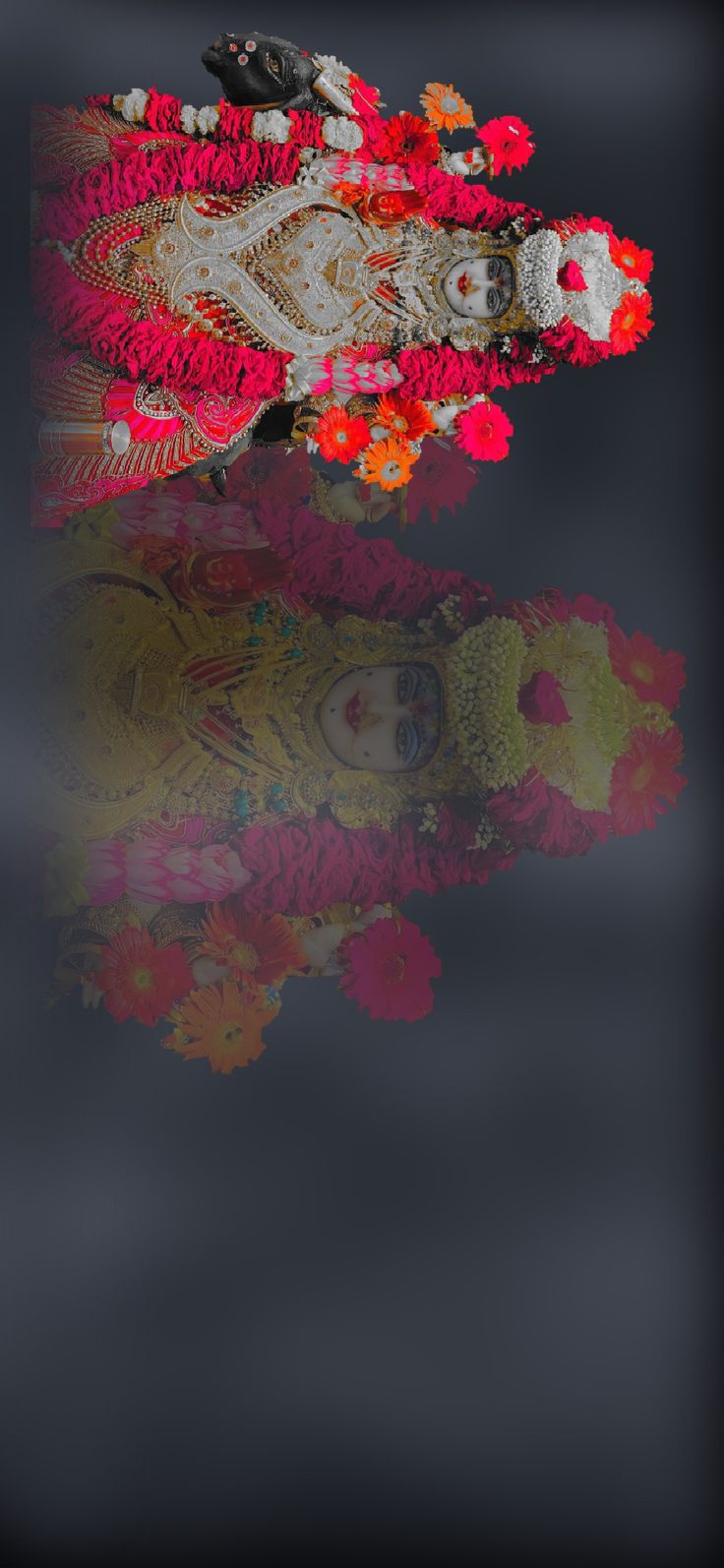 an image of a statue with flowers on it's head and reflection in the water