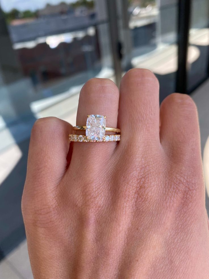 a woman's hand with a ring on it and a diamond in the middle