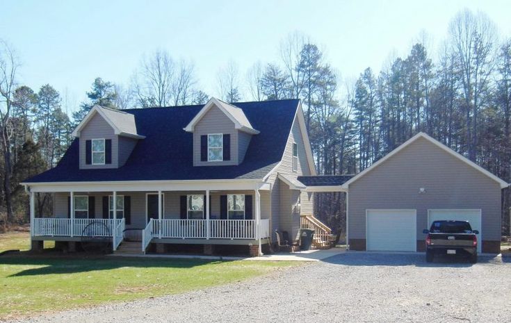 a car parked in front of a house with two garages on each side of the driveway